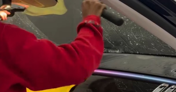 Dark ceramic window tint being applied to a car window